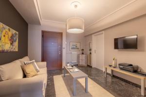 een woonkamer met een bank en een tafel bij Tranquil Central Apt, behind Athens Caravel Area in Athene