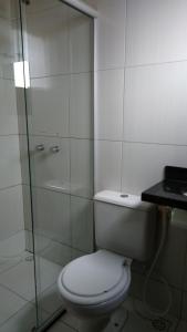 a bathroom with a toilet and a glass shower at Pousada Santana - Trindade Goiás in Trindade