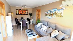 una sala de estar con un sofá y una mesa en Helena Seaview & Beach-apartment, en Montgat