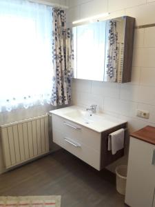 a bathroom with a sink and a mirror and a window at Ferienwohnung Kupfer in Göstling an der Ybbs