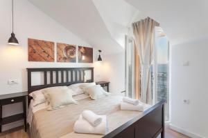 ein Schlafzimmer mit einem großen Bett und weißen Kissen in der Unterkunft Apartmani Antiqua in Živogošće