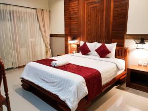 ein Schlafzimmer mit einem großen Bett mit roten Kissen in der Unterkunft Ogix Cliff Paradise in Nusa Penida