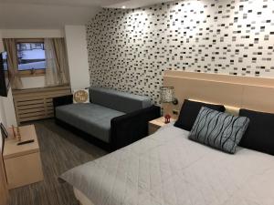 una habitación de hotel con una cama y un sofá en Apartmani Air, en Kopaonik
