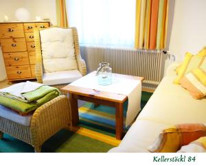 uma sala de estar com um sofá, uma mesa e uma cadeira em Kellerstöckl 84 em Moschendorf