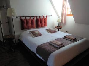 a bedroom with a large white bed with red pillows at Chambre d'Hôtes Le Moulin des Landes in Vernou-sur-Brenne