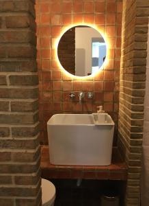 uma casa de banho com uma banheira branca e um espelho. em LUZZ me - Casa da Fuzeta na Fuzeta