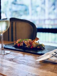a plate of food and a glass of wine on a table at Domaine du Ferret Restaurant & Spa in Cap-Ferret