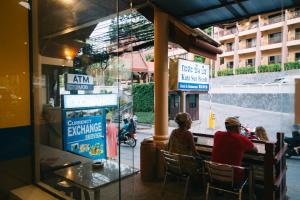 een groep mensen die buiten een restaurant zitten bij Kata Sun Beach Hotel in Kata Beach