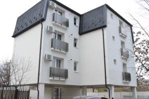 a white building with a black roof at Alexys Residence 4 in Iaşi