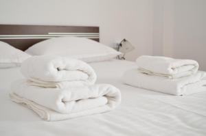 two stacks of towels sitting on a bed at Alexys Residence 4 in Iaşi