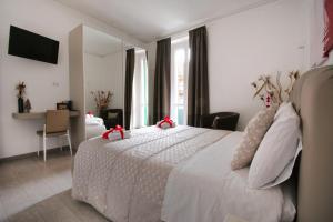 a bedroom with a white bed with red bows on it at PaneAmore in Matera