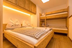 een slaapkamer met 2 stapelbedden en houten vloeren bij Ferienwohnung Aichner in Mittersill