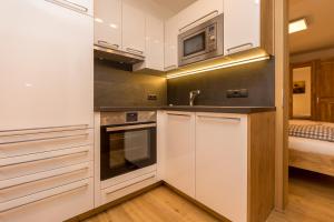 een keuken met witte kasten en een magnetron bij Ferienwohnung Aichner in Mittersill +21 foto's