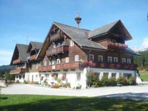 un grande edificio in legno con dei fiori di fronte di Hotel Stockerwirt a Ramsau am Dachstein