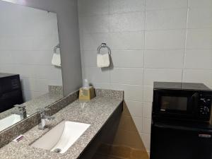 a bathroom with a sink and a microwave at Sheridan Inn in Sheridan