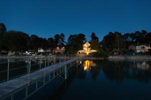 a lit up house next to the water at night at Anna Beach Villa in Siófok