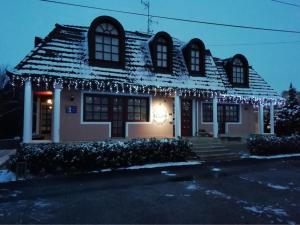 a house with christmas lights on the roof at Szilvia Gästehaus in Bük