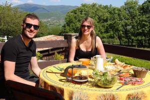 a man and a woman sitting at a table at Domaine Insolite du Petit Moras in Chomérac