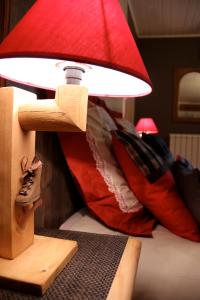 a red lamp sitting on top of a bed at Au Coeur du Lapidaire in Septmoncel