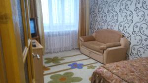 スモレンスクにあるApartamenty na Yubileynoyのリビングルーム(椅子、テレビ付)