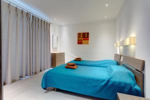 a bedroom with two beds with blue sheets at Seaview Apartment In Fort Cambridge, Sliema in Sliema +37 photos