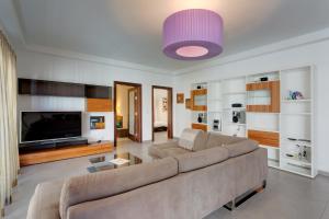 a living room with a couch and a large tv at Seaview Apartment In Fort Cambridge, Sliema in Sliema