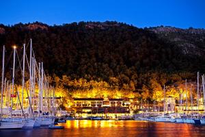 a bunch of boats docked in a marina at night at Marti Hemithea Hotel in Orhaniye