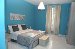 een blauwe slaapkamer met een bed en een raam bij Same as home in Caserta