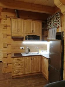 een keuken met houten kasten en een roestvrijstalen koelkast bij Domek Anielci in Zakopane