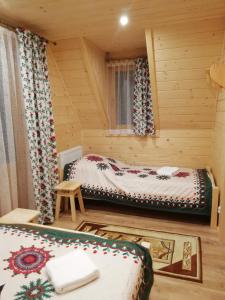a room with two beds in a log cabin at Domek Anielci in Zakopane