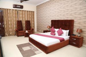 a bedroom with a large bed with pink pillows at Westin Suites in Lahore