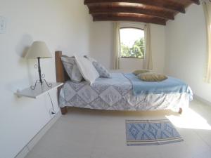 a bedroom with a bed and a window at Residencial Flor De Ipê in Paraty