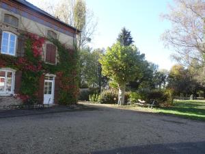 une maison avec du lierre sur son côté dans l'établissement LA BELLE D'ANTAN, à Saint-Bonnet-en-Bresse