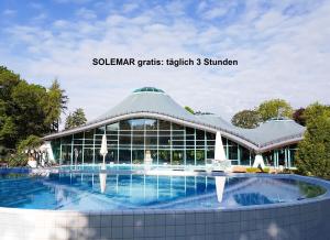 een gebouw met een zwembad ervoor bij Haus Ahorn in Bad Dürrheim