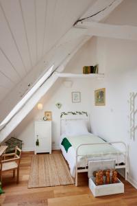 a bedroom with a white bed in a attic at Manoir des petites bretonnes in Saint-Quay-Perros