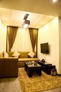 Villa 14 Suites في السادس من أكتوبر: غرفة معيشة بها أريكة وتلفزيون