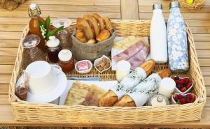una cesta llena de diferentes tipos de pan y repostería en Manoir des petites bretonnes en Saint-Quay-Perros