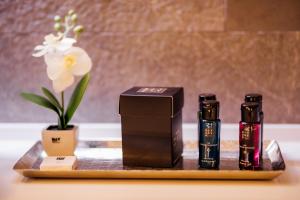 a table with two bottles of soap and a vase with flowers at Apartments Master 5 in Herceg-Novi