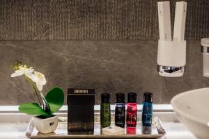 a tray with four bottles of cosmetics on a bathroom counter at Apartments Master 5 in Herceg-Novi