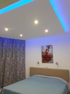 ein Schlafzimmer mit einem Bett und einem blauen Licht in der Unterkunft Sunorama Beach Garden 302 in Larnaka