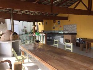 a large kitchen with a large wooden table and chairs at Vista Maravilhosa do Mar! in São Sebastião