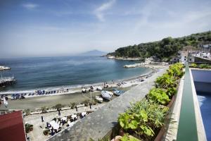 a view of a beach with people and the ocean at Hotel Baia Di Puolo in Massa Lubrense