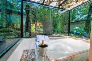 a bath tub in a room with a large window at Resort Magnifico in Monte Verde