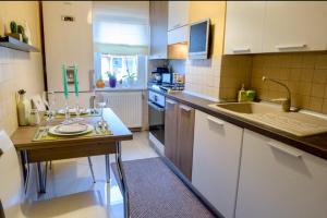 a kitchen with white cabinets and a table with glasses on it at Zuzu’s home in Râşnov