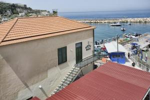 a building with a staircase next to the water at Hotel Baia Di Puolo in Massa Lubrense