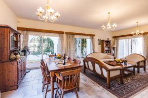 een woonkamer met een tafel en stoelen en een bank bij Villa Papaya Residence in Paphos City