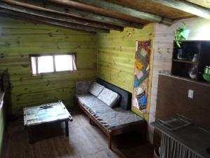 um quarto com um sofá numa cabana de madeira em AMBRA em Punta Del Diablo