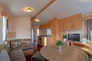 a living room with a table and a kitchen at Mobilheim Viktorie in Výrovice