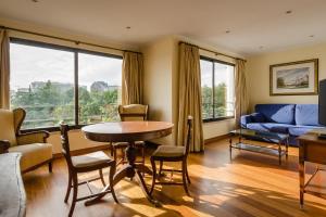 リスボンにあるLisboa Central Park Hotel Suites & Studiosのリビングルーム(テーブル、椅子、ソファ付)