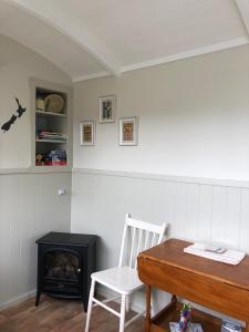 Cette chambre comprend une table, une chaise et une cuisinière. dans l'établissement The Shepherd's Rest, à Oamaru